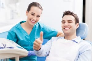 Dentist with happy patient after treating TMJ pain